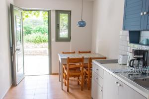 a kitchen with a table with chairs and a counter top at Despina Studios and Apartments in Lassi