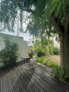 une terrasse en bois avec deux chaises et une table dans l'établissement Jolie maison quartier Vesone, à Périgueux