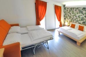 a bedroom with two beds and a couch and a window at Eco Hotel Cleofe in Caorle