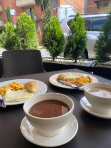 uma mesa com pratos de comida e uma tigela de sopa em Hotel Urbano 70 em Medellín