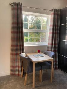 a table and two chairs in front of a window at The Old Coach House in Llangollen