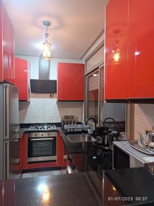 a kitchen with red cabinets and a sink at Mourisse House in Imsouane