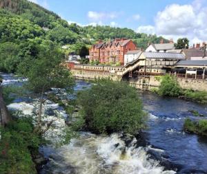 a river with a town in the background at The Old Coach House in Llangollen