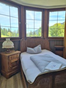 a bed sitting in a room with windows at Berghotel Almagmach in Immenstadt im Allgäu