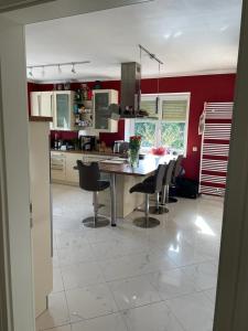 a kitchen with a table and chairs and red walls at traumhaft edle Landhauswohnung in Rosengarten