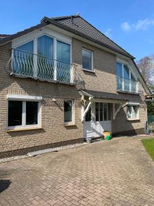 a brick house with a balcony on top of it at traumhaft edle Landhauswohnung in Rosengarten
