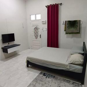 1 dormitorio con cama y cortina roja en Zeeyad Homestay dan Roomstay, en Kuala Terengganu