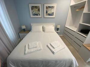 ein Schlafzimmer mit einem weißen Bett mit zwei Platten darauf in der Unterkunft Casa do Mar - Ribeira Quente Azores in Ribeira Quente