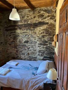 - une chambre avec un lit dans un mur en pierre dans l'établissement Medulillas 1 Casa a 2000 m de Las Médulas, à Yeres
