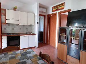 a kitchen with white cabinets and a table with a counter top at Residence La Playa in Marina di Camerota