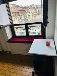 una vela roja sentada en un banco frente a una ventana en Charmant studio très accueillant, en Ginebra
