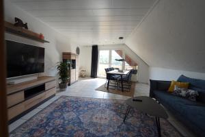 a living room with a blue couch and a table at SANO Apartments - Bei Volkmar in Herdecke
