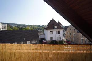 a white house with a brown roof and some buildings at SANO Apartments - Bei Volkmar in Herdecke