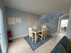 ein Esszimmer mit Tisch und Stühlen und einer Treppe in der Unterkunft Casa do Mar - Ribeira Quente Azores in Ribeira Quente