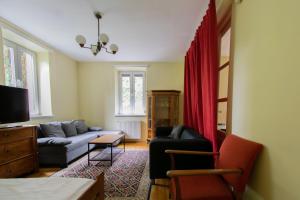 uma sala de estar com um sofá e cortinas vermelhas em House with Garden Królowej Jadwigi street em Cracóvia