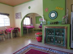 un soggiorno con camino e una sala da pranzo di Aloepark Art Hotel a Naivasha Altre 37 foto