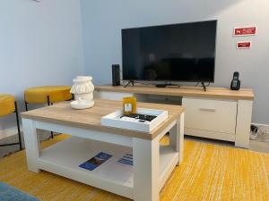 ein Wohnzimmer mit Fernseher und Couchtisch in der Unterkunft Casa do Mar - Ribeira Quente Azores in Ribeira Quente