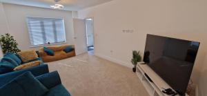 a living room with a large flat screen tv at Brand new Entire 4-Bed House in Peterborough in Peterborough