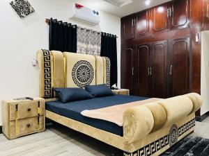 a bedroom with a large bed with a couch at The Comfort Lodge in Islamabad