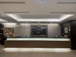 a lobby with a reception counter and clocks on the wall at Young Soarlan Hotel - Tainan in Tainan