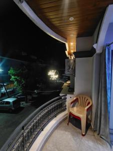 a chair on the balcony of a hotel at night at HOTEL ANJALI in Ujjain