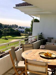 una mesa y sillas en un balcón con vistas en Duplex vistas al golf Guadalmina Marbella, en Marbella
