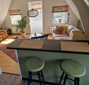 uma sala de estar com um balcão e dois bancos em Zonnig appartement Maasbommel. em Maasbommel