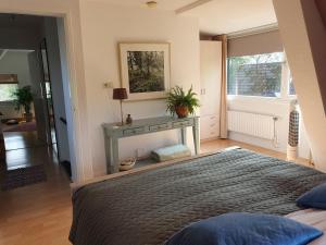 1 dormitorio con cama, mesa y ventana en Zonnig appartement Maasbommel., en Maasbommel