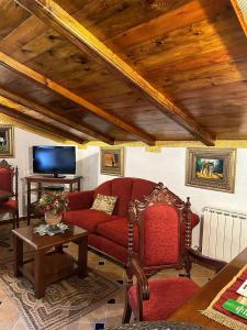 a living room with a red couch and a table at Hotel Rural Convento Santa Maria de la Sierra in Arroyo Frio