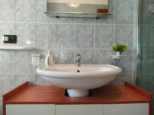 een witte wastafel in een badkamer met tegels bij Casa quinto piano - intero appartamento con garage in Vicenza