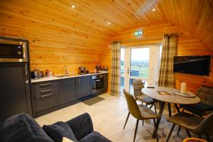 a kitchen and dining room of a log cabin at Berstane Lodges in Orkney