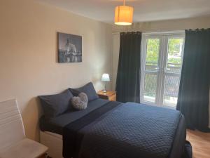 um quarto com uma cama azul e uma janela em Wilmot Close em Londres