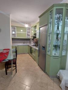 a kitchen with green cabinets and a table and a table and a tableablish at Buneci apartment in Tirana +13 photos