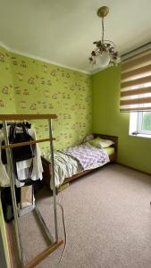 sypialnia z łóżkiem i zieloną ścianą w obiekcie Mountain View Cozy House w mieście Baytyk