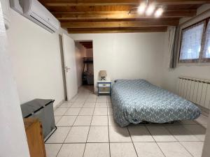 1 dormitorio con 1 cama y suelo de baldosa en GITE DES PHARES - sorties en bateau prive et visites guidees, en Lesparre-Médoc