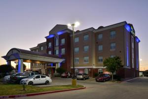a hotel with cars parked in a parking lot at Holiday Inn Express Hotel & Suites Royse City - RockwallRockwall - Royse City, an IHG Hotel in Royse City