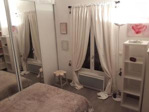 a bedroom with a bed and a window with curtains at Un nid près de Paris in Rueil-Malmaison