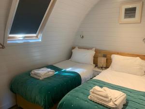 two beds in a small room with a window at ThePod in Penzance