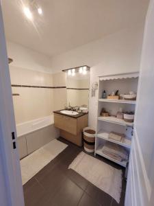 a bathroom with a tub and a sink and a bath tub at Gerland T2 standing - balcon - parking privé souterrain in Lyon