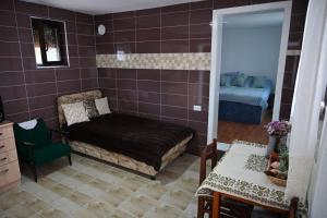 a bedroom with a bed and a chair and a table at Oplenacki smestaj Milica in Topola