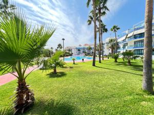 un parc avec des palmiers et une piscine dans l'établissement PUSHE Castell de Ferro Beach & Tradition 2, à Castell de Ferro