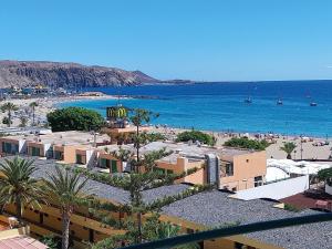a view of a beach with palm trees and buildings at SOL & MAR Playa de las vistas Torres del Sol A504 in Arona