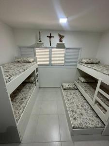 Cette chambre comprend 3 lits superposés et une croix. dans l'établissement Ap.Condomínio da Fe (1-6pessoas*, à Cachoeira Paulista