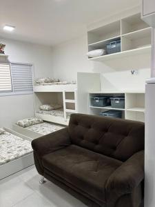 - un salon avec un canapé brun et des étagères dans l'établissement Ap.Condomínio da Fe (1-6pessoas*, à Cachoeira Paulista