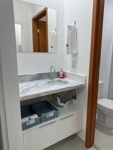 La salle de bains est pourvue d'un lavabo et de toilettes. dans l'établissement Ap.Condomínio da Fe (1-6pessoas*, à Cachoeira Paulista
