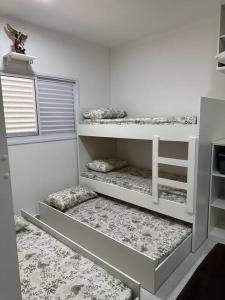 Cette chambre blanche comprend 3 lits superposés. dans l'établissement Ap.Condomínio da Fe (1-6pessoas*, à Cachoeira Paulista