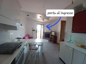 a kitchen with a white counter and a table in it at Casa Venera. Bella, zona centrale in Pisa