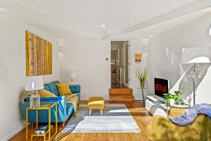 a living room with a blue couch and yellow chairs at 3 Bedroom Mews Home - Clapham Common - Free Private Parking - Sleeps 5 - Newly Refurbished - Sweetpea & Pillow Properties in London