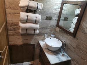 a bathroom with a sink and a mirror and towels at Lucky Cave Hotel Cappadocia in Goreme