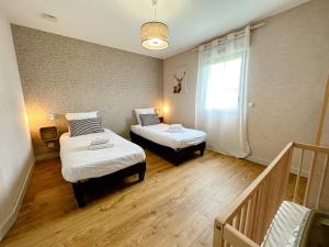 una camera con due letti e una scala con finestra di Gites-domainedupin, cottage Bain Nordique PRIVÉ a Mosnes